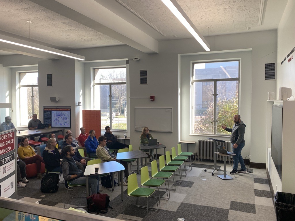 speaker presenting in front of a group at GIS Day 2023